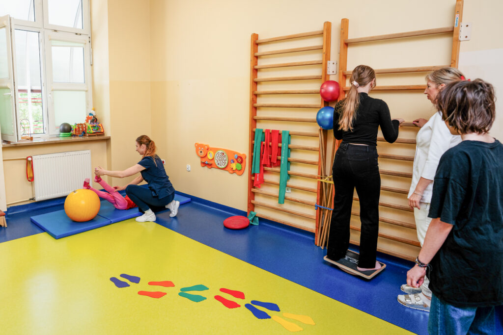 Sala do rehabilitacji, dzieci ćwiczące na przyrządach